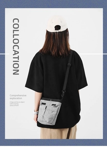 Vista posteriore di una borsa a tracolla in nylon grigio con cinturino sul modello