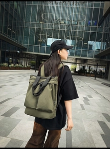 Détail du sac à dos cabas en nylon vert armée montrant le tissu et les poches avant