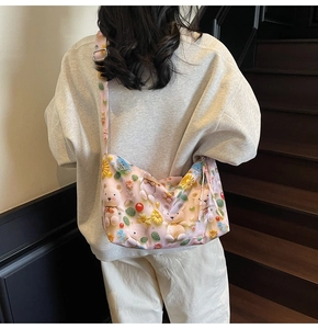 Pink cartoon crossbody bag with cute 3D bear and bunny charms worn on shoulder