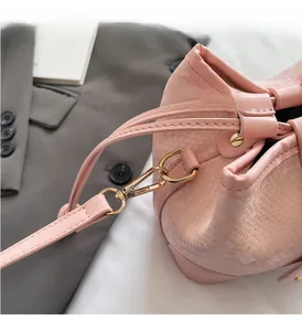 Close-up of pink snakeskin bucket bag with premium gold hardware and leather texture