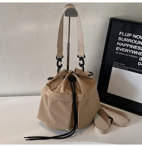 Detail van kaki bucket bag met trekkoord, canvas textuur en afneembare schouderriem
