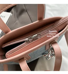 Detail view of smooth silver zipper and sparkling rhinestone denim patchwork on pink bag