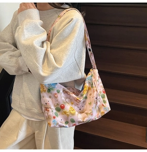 Pink tote bag detail with 3D crochet print of bears and flowers on model shoulder