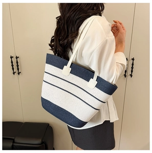 Détail du sac fourre-tout tressé à rayures bleu marine et blanc avec fines anses cuir