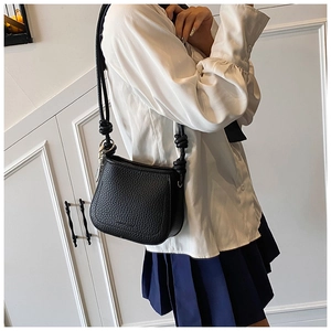 Detail of black lychee grain saddle bag with unique knotted rope shoulder strap design