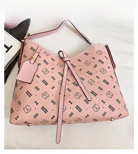 Detail view of pink tote with cartoon bear prints and protective gold bottom studs