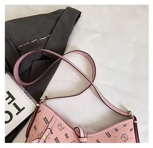 Close-up of pink leather hobo bag with teddy bear pattern and gold metal hardware