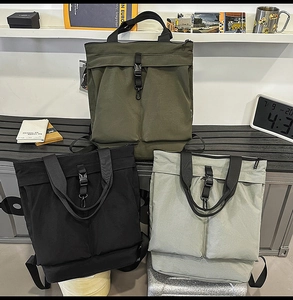 Trois sacs cabas en nylon en vert armée, noir et gris dans un décor moderne chic