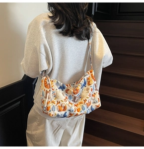 Detail of cartoon forest animal print tote bag worn as a crossbody on a model's back
