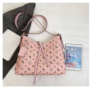 Detail view of pink bear pattern shoulder bag with ribbon bow and metal bag feet