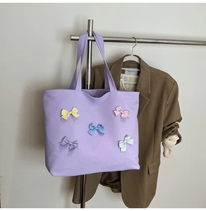 Detail of purple plaid canvas tote bag with five colorful polka dot bows for a chic look