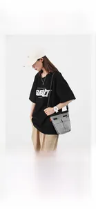 Borsa a tracolla in nylon grigio neutro mostrata su un modello per riferimento taglia