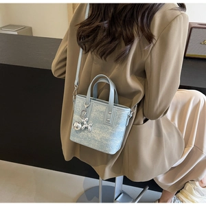 Rear view of a light blue mini bucket bag with glitter fabric and balloon dog charm