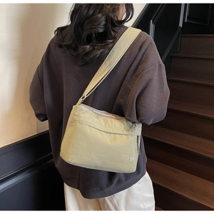 Detail view of olive green nylon tote bag on a model featuring smooth waterproof texture