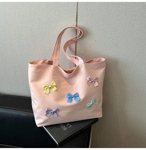 Detailed close-up of pink canvas tote bag with five colorful polka-dot ribbon bows