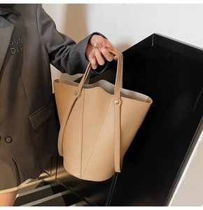 Detail of khaki bucket bag showing tulip shape, litchi texture, and metal rivets