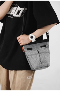 Dettaglio della borsa a tracolla in nylon grigio con doppie tasche e cinturino