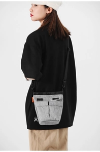 Borsa a tracolla grigia in nylon con texture stropicciata ed etichetta arancione vivace