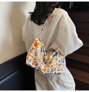Detail of cartoon animal print canvas bag with wide strap on a model on stairs