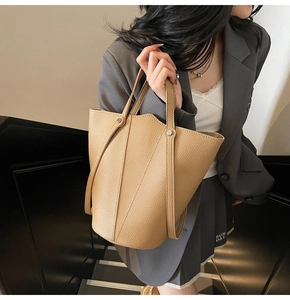 Detail view of khaki leather bucket bag with lychee texture and seamless strap handle