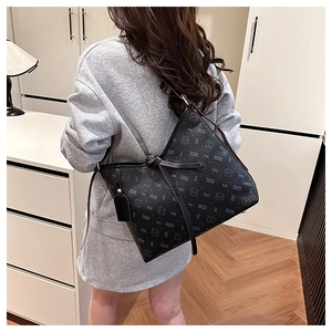 Detail of black tote bag with white bear print and long handles for shoulder wear