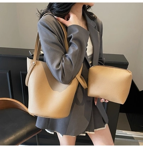 Detail of khaki pebbled leather bucket bag set with twin handles and inner pouch