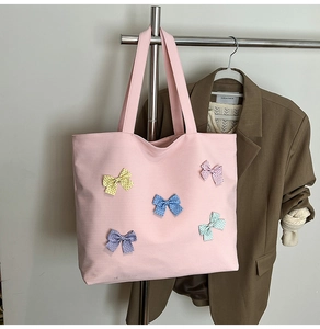 Detail of pink canvas tote bag featuring five colorful polka dot ribbon bows decorations