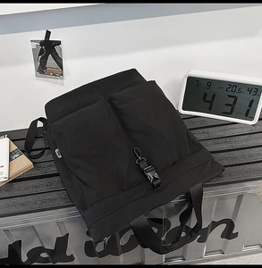 Détails du sac cabas minimaliste en nylon noir avec deux poches avant et fermoirs à boucles