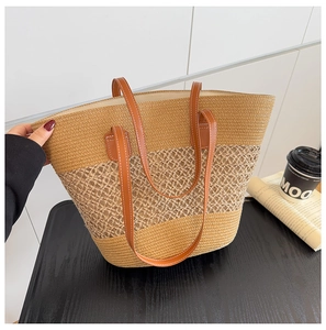 Detalle de un bolso tote tejido grande con texturas de tres tonos y asas de cuero marrón