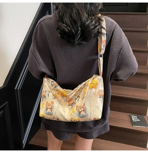 Detail of adjustable strap and floral bear embroidery on beige canvas tote bag