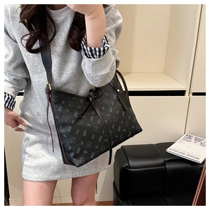 Detailed view of the black hobo bag featuring playful cat prints and stylish ribbon tie