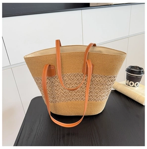 Detalle del bolso tote de paja tejida con correa de cuero marrón y texturas tricolores