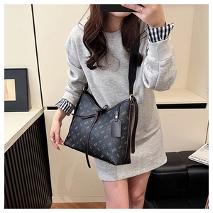 Detail of vintage black printed hobo bag with bow tie and wide fabric strap shown on model