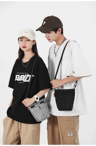 Borse a tracolla in nylon nero e grigio con design multi-tasca indossate dai modelli