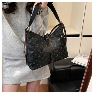 Detail of black leather shoulder bag with printed bear patterns and bow tie accent