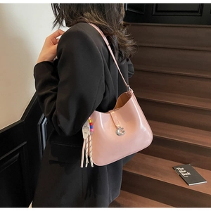 Pink crescent shoulder bag in glossy patent leather with silver G buckle and beaded charm