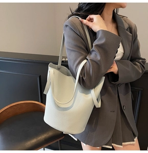 Detail of white litchi pattern leather bucket bag with elegant textured finish