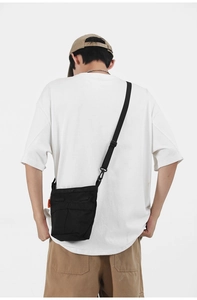 Vista posteriore della borsa a tracolla nera in nylon su modello in stile casual