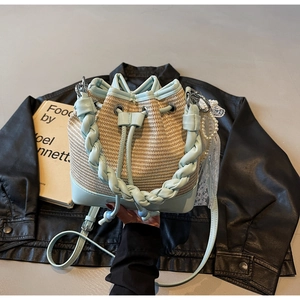 Detail of woven straw and light blue leather bucket bag with pearl and lace accents