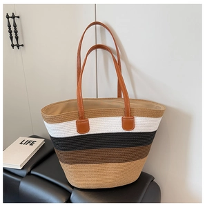 Detalle macro del bolso tote de paja tejida multicolor con asas de cuero y costuras