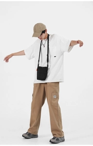Outfit urban da uomo con t-shirt bianca oversize e pantaloni cargo kaki con borsa a tracolla