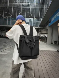 Grand sac fourre-tout en nylon noir porté comme un sac à dos dans un cadre urbain moderne