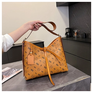 Close-up of vintage brown crossbody bag with bear monogram pattern and metallic bottom studs