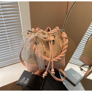 Close-up of pink leather trim and beige woven straw texture with lace bow and pearl charms