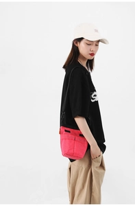 Dettaglio della borsa a tracolla in nylon fucsia con tasche frontali e tracolla