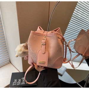 Detailed view of pink snakeskin pattern bucket bag with cute plush sheep keychain
