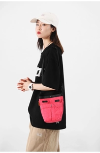Modello con borsa a tracolla in nylon rosso rosa con doppie tasche frontali e fibbia