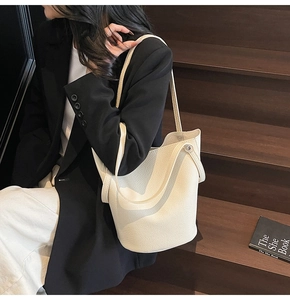 Detail of off-white lychee grain bucket bag with slim shoulder strap and urban styling