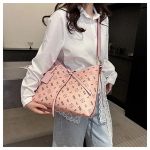 Detail of pink faux leather tote bag with cartoon bear prints and side ties for commute