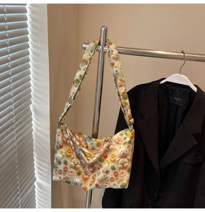 Detailed shot of cream shoulder bag with 3D plush bears and colorful handmade flowers